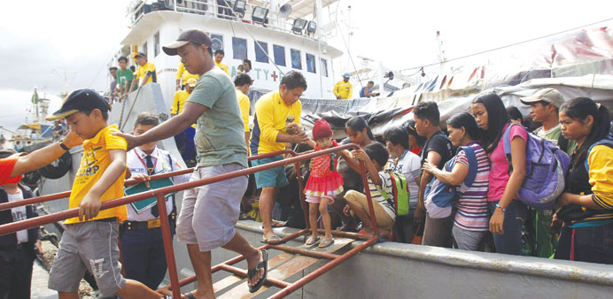 Survivors of Super Typhoon Haiyan disembark from a Philippine Navy ship upon arrival at the north harbour in Manila yesterday.