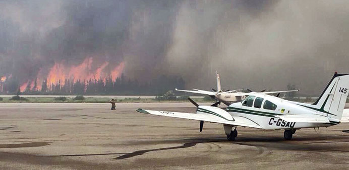Flames from a forest fire approach the airport outside the town of La Ronge, Saskatchewan, on Sunday.