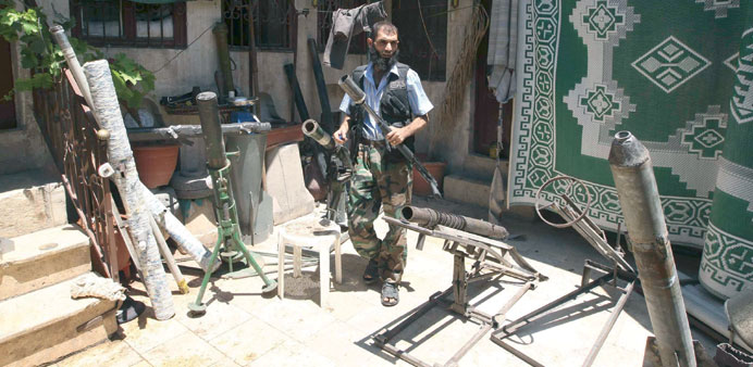 A Free Syrian Army fighter gathers homemade weapons in the old city of Aleppo yesterday.