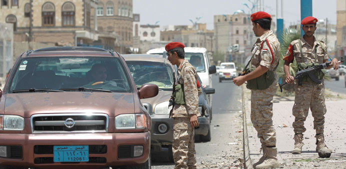 Soldiers stand guard in Sanaa yesterday as they check passing vehicles amid tightened security measures.