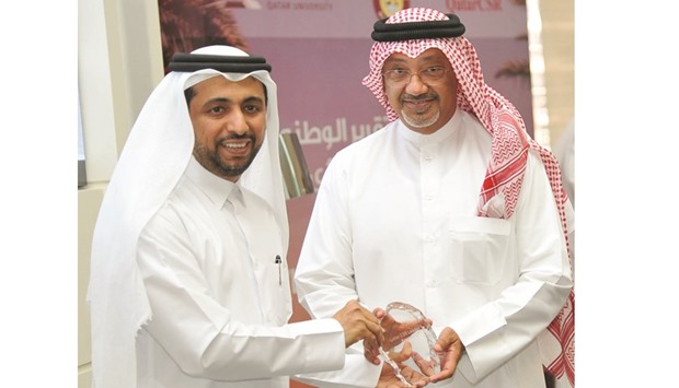 Abdulla Saleh al-Raisi, right, receiving the award from QU president Dr Hassan Rashid al-Derham.
