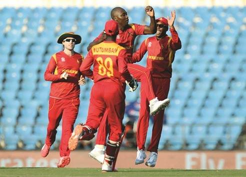 Zimbabweu2019s Tendai Chatara (third left) celebrates with teammates after dismissing Scotlandu2019s Matt Cross during the World T20 cricket match at the Vidarbha Cricket Association Stadium in Nagpur yesterday. (AFP)