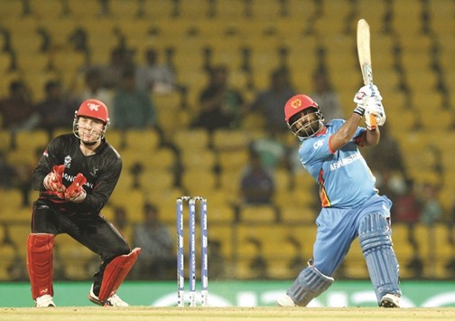 Afghanistanu2019s Mohammad Shahzad plays a shot as Hong Kongu2019s wicketkeeper Jamie Atkinson looks on  during the World T20 cricket match at the Vidarbha Cricket Association Stadium in Nagpur, Western India, yesterday. (AFP)