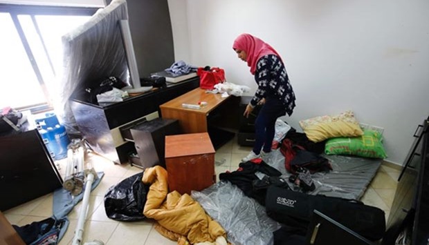 A Palestinian woman inspects the damage at the Palestine Today television offices after it had been raided by Israeli forces in Ramallah.