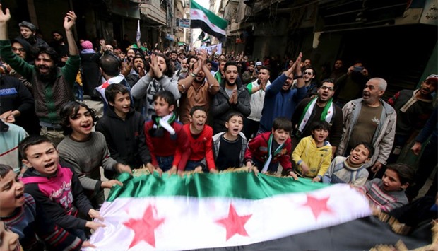 Protesters shout slogans and carry Free Syrian Army flags during an anti-government protest in the al-Sukari neighborhood of Aleppo. Reuters