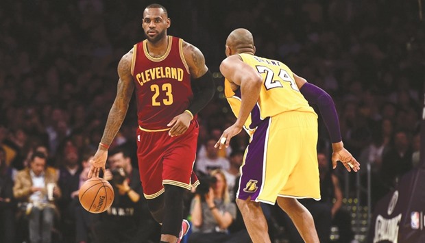 LeBron James (23) of the Cleveland Cavaliers dribbles as he is guarded by Kobe Bryant of the Los Angeles Lakers during the first half of their game in Los Angeles on Thursday.