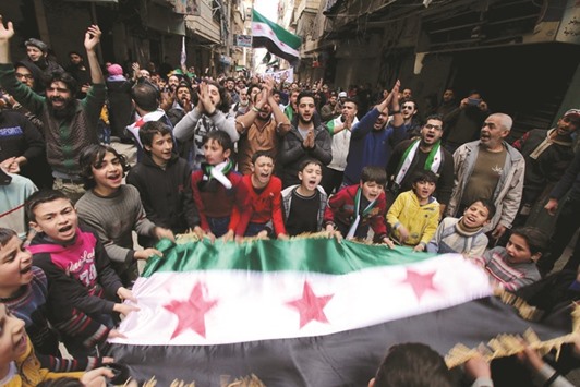 Protesters shout slogans and carry Free Syrian Army flags during an anti-government protest in the Al Sukari neighborhood of Aleppo, Syria yesterday.