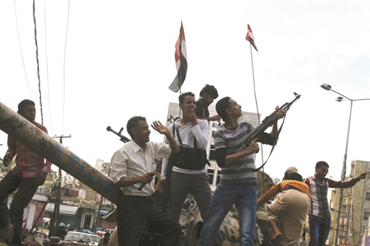 Pro-government fighters open fire into the air to celebrate after they took the Bir Basha neighbourhood from Houthi fighters in the Yemen city of Taez.