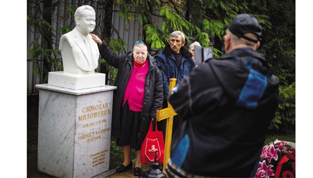 Supporters of Milosevic pose for a photograph next to his grave in the town of Pozarevac.