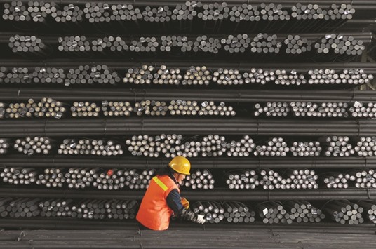 A labourer marks steel bars at a steel and iron factory in Jiangsu province. China aims to lay off millions of state workers over the next two to three years as part of efforts to curb industrial overcapacity and pollution, two reliable sources said yesterday.
