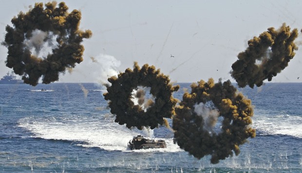 Amphibious assault vehicles of the South Korean Marine Corps fire smoke bombs as they move to land on the shore in Pohang.