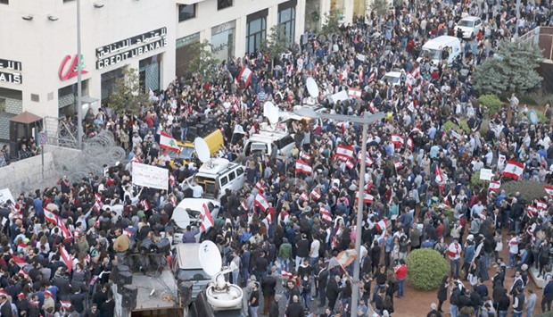 Protesters carry Lebanese flags and banners as they take part in a protest against what they say is the governmentu2019s failure to resolve a crisis over rubbish disposal near the government palace in Beirut yesterday.