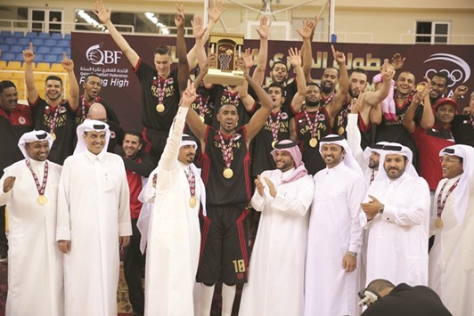 Qatar Basketball Federation chief Sheikh Saoud bin Abdulrahman al-Thani and other officials applaud as Al Rayyan captain Yaseen ismail Musa holds aloft the Qatar Basketball League trophy after their win over Al Sadd yesterday.