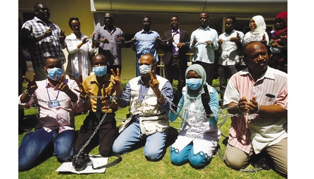 Sudanese journalists pose with chains outside the Tayar newspaper to announce a hunger strike yesterday in protest against a decision to withhold the publication of the newspaper.