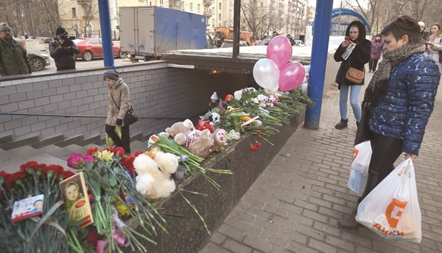 A woman mourns at the site where a woman suspected of killing a toddler was detained on Monday, near Oktyabrskoye Pole metro station in Moscow. Moscow police arrested on Monday a woman for beheading the girl in her care, with witnesses saying that the black-clad woman was carrying a severed head and threatening to u2018blow everyone upu2019.