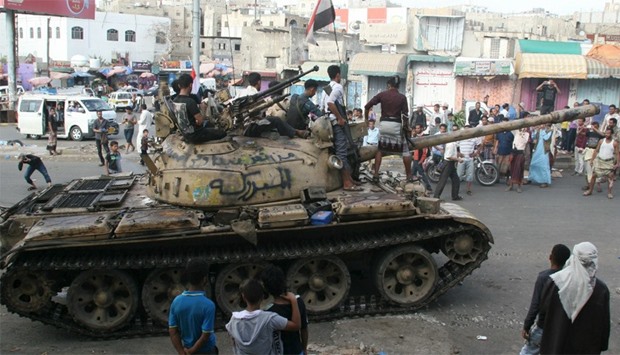Pro-government fighters ride on a tank in the Bir Basha neighbourhood