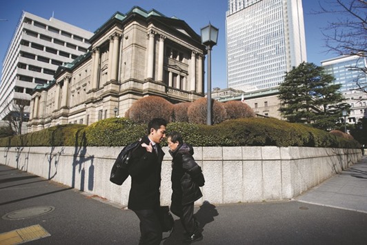 Pedestrians walk past the Bank of Japan headquarters in Tokyo. The BoJ policy board is set to discuss this week whether to exempt $90bn in short-term funds from its newly imposed negative interest rate, according to reports.