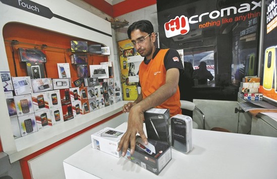 A worker displays a Micromax mobile phone inside a store in Kolkata. A year ago, Micromax vaulted past Samsung Electronics to become Indiau2019s leading smartphone brand. Today, its market share has nearly halved, several top executives have resigned, and the company is looking for growth outside India.