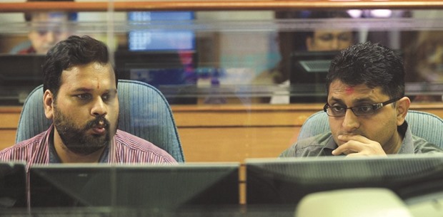 Indian stock brokers watch share prices on their trading screens at a brokerage house in Mumbai (file). The Sensex, which tumbled into a bear market last month, is still valued at a 47% premium over a gauge of emerging markets.