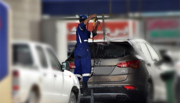 A car wash attendant cleans a vehicle