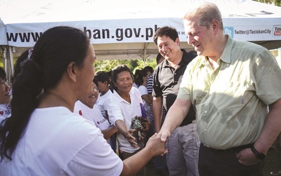 Former US vice-president Al Gore (right) shaking hands with survivors of super typhoon Haiyan during a visit to the mass grave for victims of the typhoon, in Tacloban City, central Philippines.