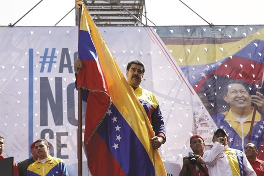Venezuelau2019s President Nicolas Maduro holds the national flag during a rally in Caracas.