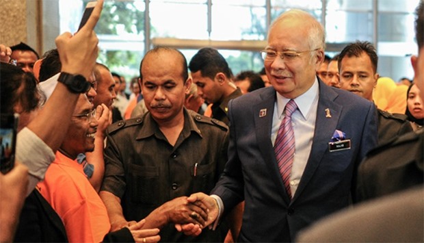 Malaysia's Prime Minister Najib Razak (C) shakes hands with supporters