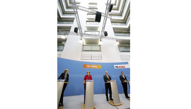 Merkel, Reiner Haselofft (second right), the top candidate in the Saxony-Anhalt state election, Guido Wolf (right), the top candidate in the Baden-Wuerttemberg state election, and Julia Kloeckner, the top candidate in the Rheinland-Palatinate state election, address a news conference at CDU party headquarters in Berlin. The words behind Merkel read u2018The Middleu2019.