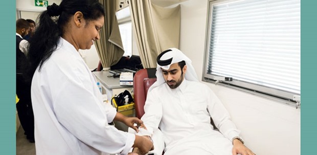 A Qatargas employee donates blood at the companyu2019s Doha head office.