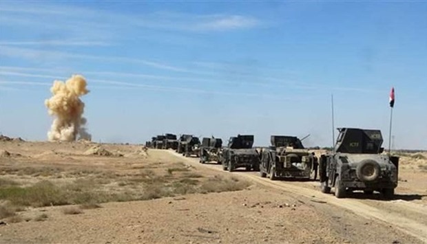 Iraqi security forces vehicles move toward the town of Hit during a military operation.