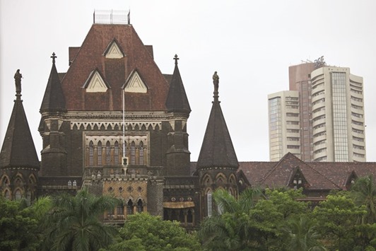 The Bombay Stock Exchange (right) is seen behind the Bombay High Court building in Mumbai. The benchmark BSE Sensex closed down 253.11 points to 24,551.17 yesterday.
