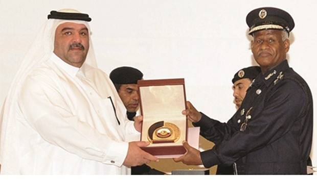 Hassan Abu Khamis receiving the certificate and memento from Brigadier Aman Saad al-Sulaiti.
