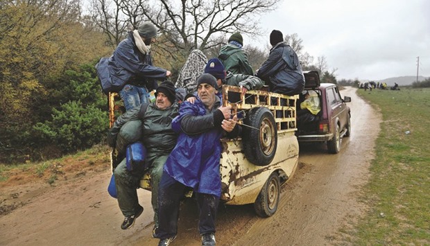Refugees are given a lift as they make their way back to a makeshift camp at the Greek-Macedonian border, near the Greek village of Idomeni yesterday.