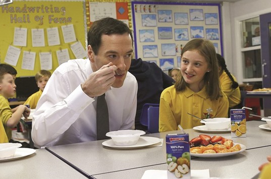 Chancellor of the Exchequer, George Osborne, eats with pupils during breakfast club at St Benedictu2019s Catholic Primary School in Garforth.