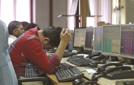 A trader reacts while trading at a brokerage firm in Mumbai. The Sensex wiped out a 1.1% gain in late trade to close at 24,677.37 yesterday.