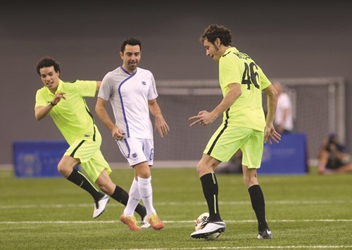 Valentino Rossi (right) and Xavi (centre) in action during a friendly at Aspire Academy on Wednesday.