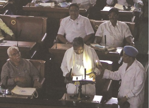 Karnataka Chief Minister Siddaramaiah presents the state budget in the legislative assembly in Bengaluru under emergency lights as the house witnessed power cuts twice yesterday.