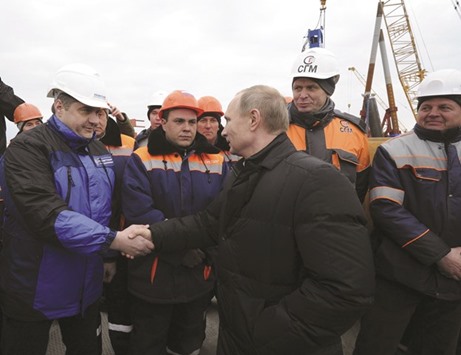 Putin meets workers during a visit to the construction site of the transport passage across the Kerch Strait, on Tuzla island near the Black Sea port of Kerch, Crimea.