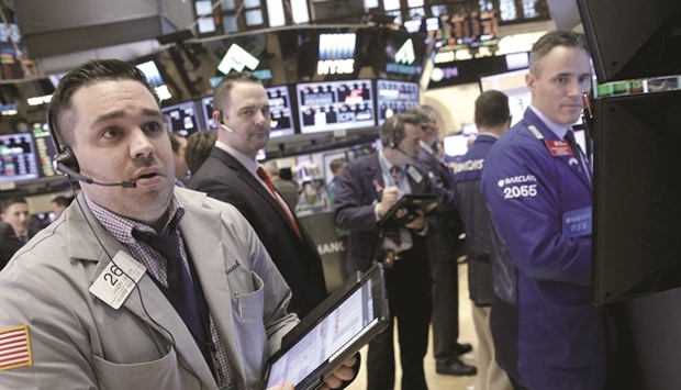 Traders work on the floor of the New York Stock Exchange (file). The US investors will be watching currency markets this week for signs that the recent, related trends of a weakening dollar and a strengthening stock market will continue.
