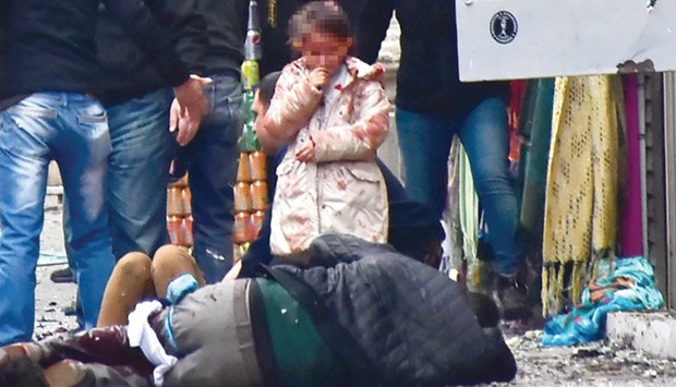 A child (her face digitally concealed) is seen in shock in the aftermath of the suicide bombing. Her condition is unknown.