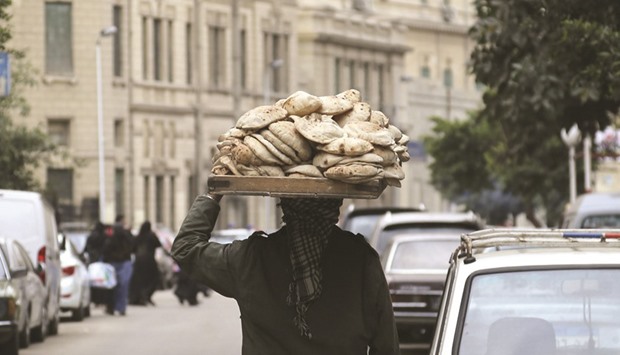 A man carries freshly baked bread on his head along a street in Cairo in this photo taken on February 8. Egypt is the worldu2019s biggest importer of the grain, in large part because Cairo runs a bread subsidy programme that feeds tens of millions of poor Egyptians. Wheat shortages have triggered riots in the past, and when Egyptians rose up against autocrat Hosni Mubarak in 2011 one of their signature chants was u201cBread, freedom and social justice.u201d