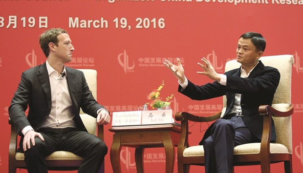 Facebook founder and CEO Mark Zuckerberg looks at founder and executive chairman of Alibaba Group Jack Ma during the China Development Forum in Beijing yesterday.