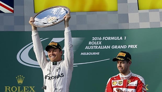 Mercedes F1 driver Nico Rosberg (left) celebrates after winning the Australian Formula One Grand Prix as third-place Ferrari F1 driver Sebastian Vettel looks on in Melbourne.