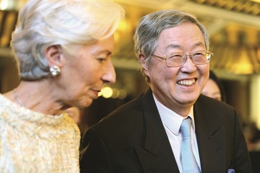 Zhou Xiaochuan (right), governor of the Peopleu2019s Bank of China laughs as he leaves with IMF managing director Christine Lagarde after a session of the China Development Forum in Beijing yesterday. China still has a problem with illegal fundraising and financial services are insufficient, Zhou said in a speech at the forum.