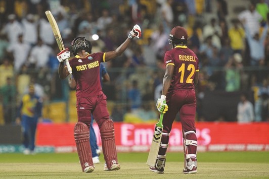 West Indies batsmen Andre Fletcher (left) gestures after the win over Sri Lanka even as his partner Andre Russell looks at the Chinnaswamy Stadium in Bangalore yesterday. (AFP)