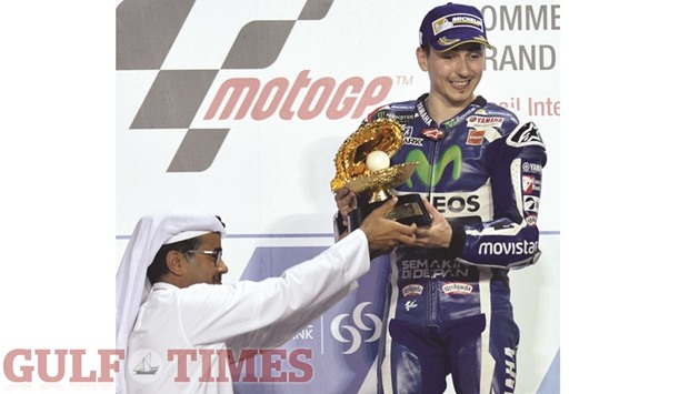 Movistar Yamaha rider Jorge Lorenzo receives the trophy after winning the Commercial Bank Grand Prix of Qatar at Losail International Circuit yesterday. PICTURES: Noushad Thekkayil