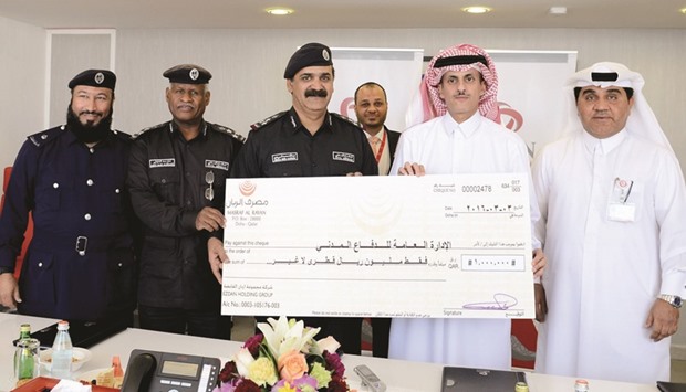 Ezdan Holding chairman Sheikh Dr Khalid bin Thani bin Abdulla al-Thani presenting the cheque to GDCD director general Staff Brigadier General Abdulla Mohamed al-Suwaidi.