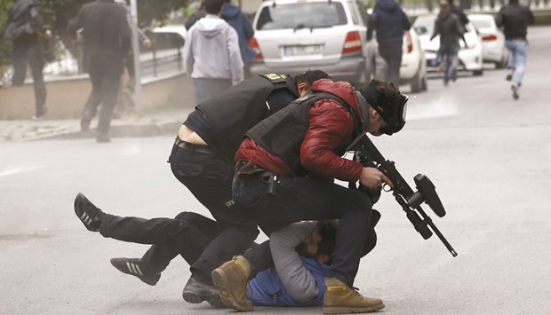Riot police detain a pro-Kurdish demonstrator during a gathering in Istanbul to celebrate the spring festival of Newroz despite a ban from the governorship.