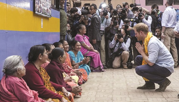 Prince Harry interacts with a group of local women while he visits Patan Durbar in Patan, a Unesco World Heritage Site, in Kathmandu yesterday.