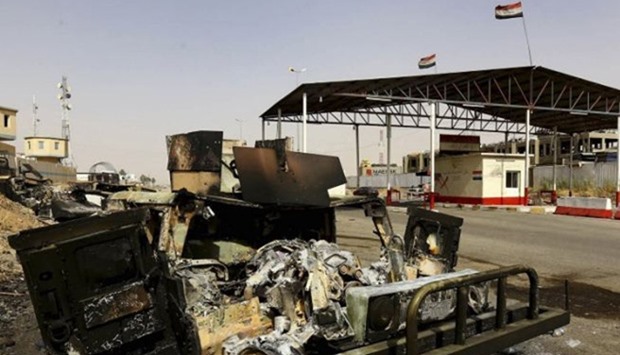 Burnt vehicles belonging to Iraqi security forces are pictured at a checkpoint